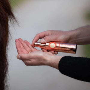 Pumping Regrow Hair Regrowth Treatment into hand before applying to horse's tail